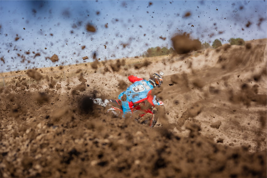 Motocross Rider Kicking Up Dirt on Track