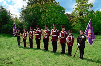 Youth marching band in red uniforms performing outdoors
