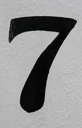Hand-painted black number seven on textured white paper background