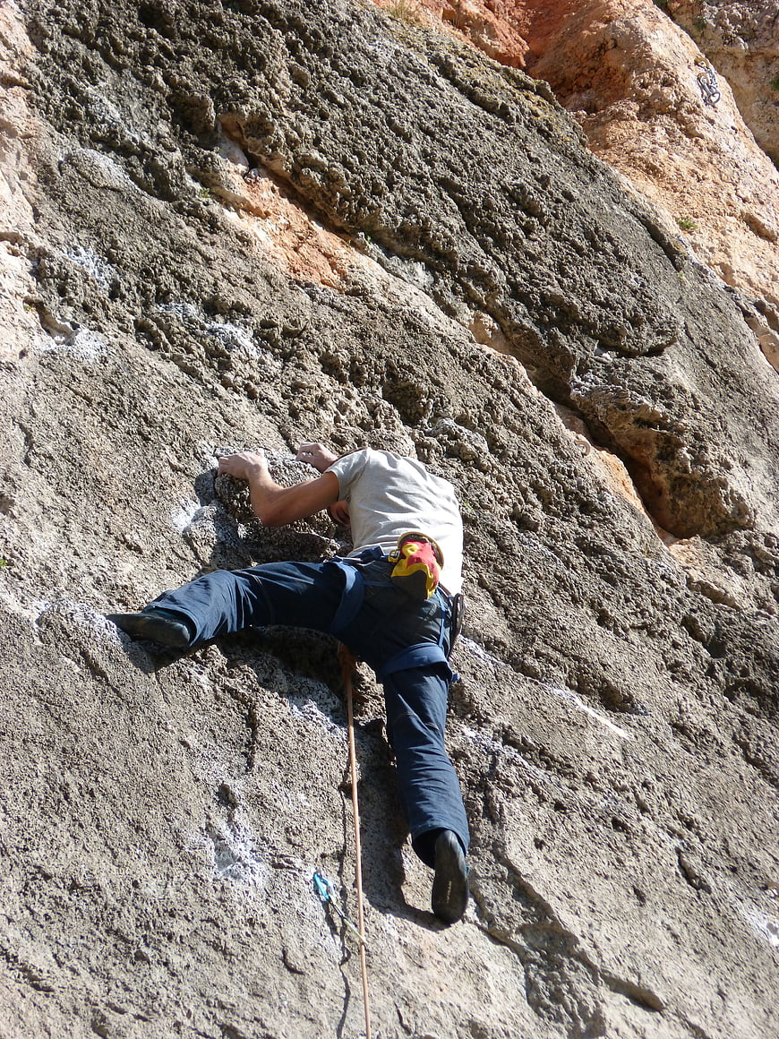 Rock Climber Scaling Steep Limestone Wall Outdoors