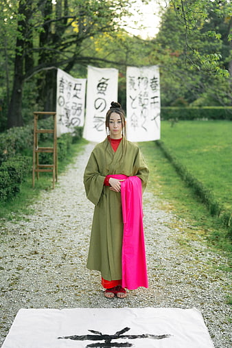 Woman in Green Kimono Standing on Gravel Path