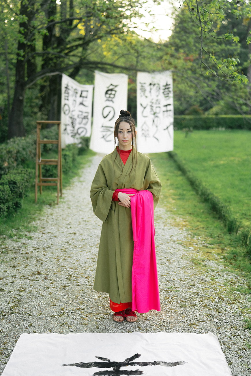 Woman in Green Kimono Standing on Gravel Path