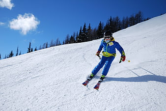 Child skiing down a snowy mountain slope on a sunny winter day