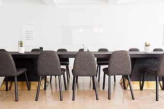Modern minimalist conference room with long dark table and gray chairs