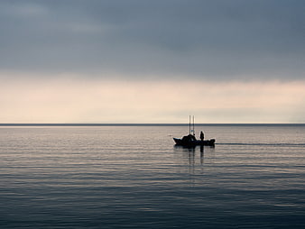 Silhouette of Fishing Boat on Calm Sea at Dawn
