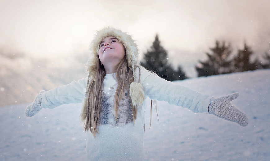 Happy Girl in Snow with Fur Hat and Mittens