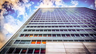 Low angle view of modern glass skyscraper against blue sky