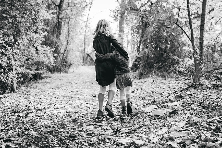 Two Girls Walking Away on Forest Path in Black and White