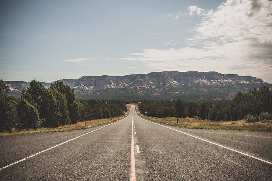 Empty Highway Stretching Toward Distant Mountains