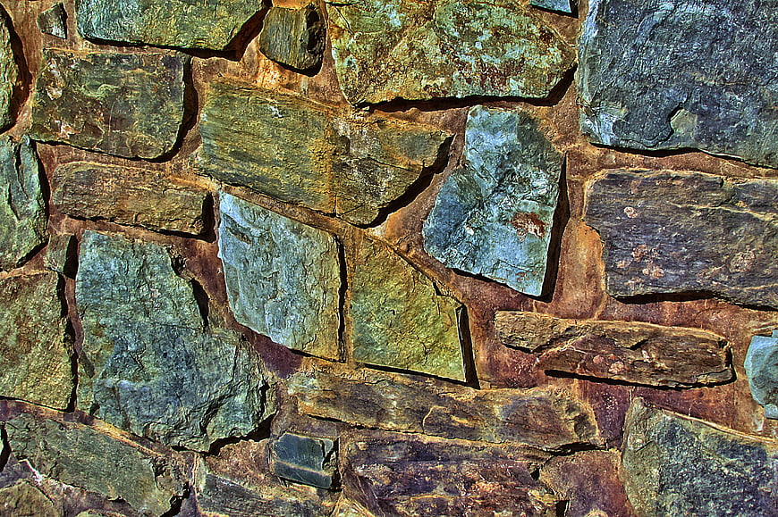 Textured Natural Stone Wall with Green and Brown Tones