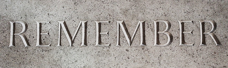 Carved word remember on textured gray stone surface