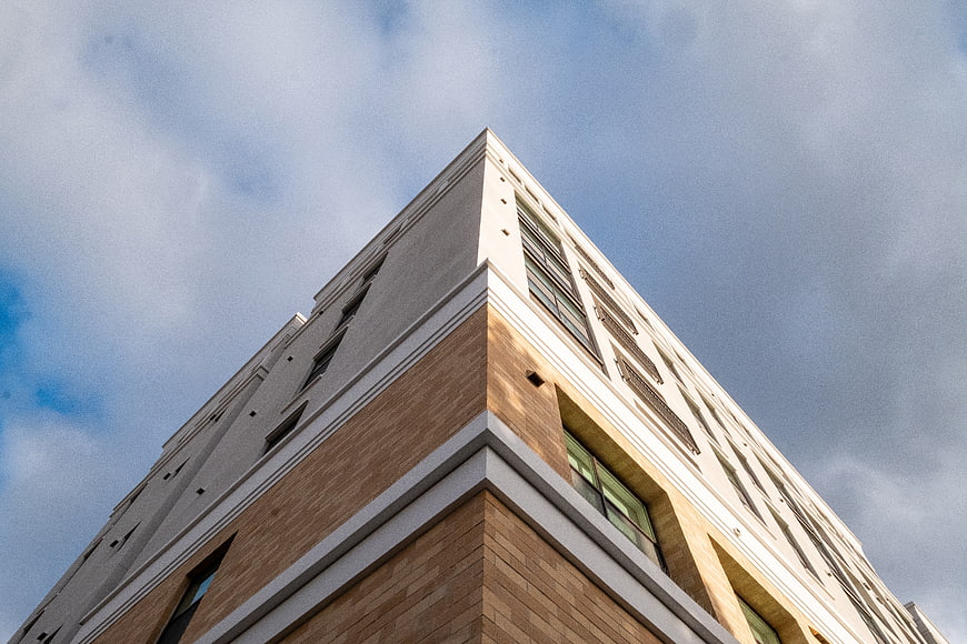 Low angle view of modern building corner against blue sky