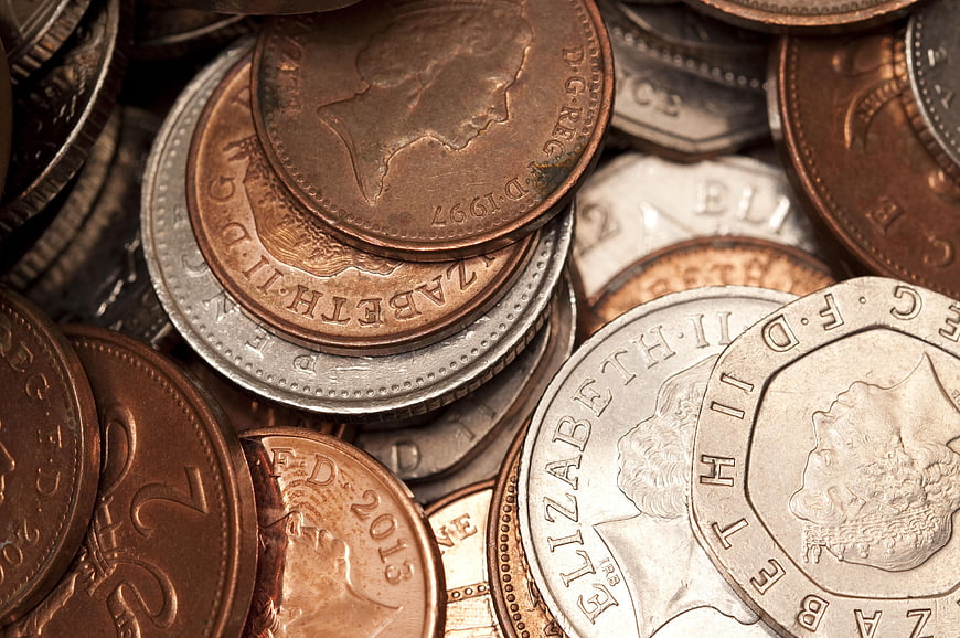 Close-up of British coins and UK currency pile
