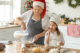Grandmother and granddaughter baking Christmas cookies in kitchen