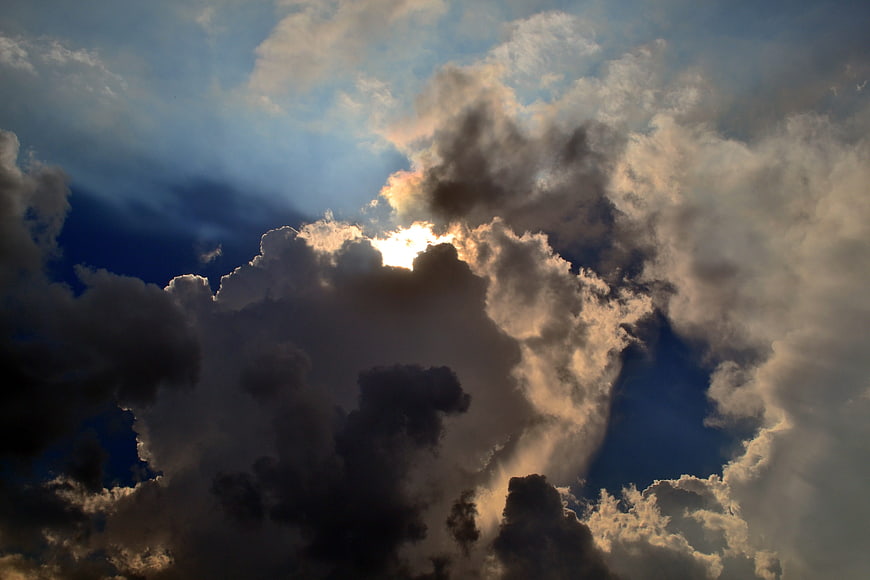 Dramatic Sun Rays Breaking Through Dark Storm Clouds