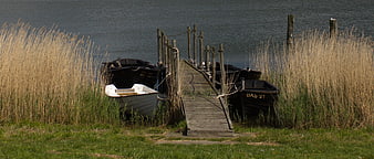 Small wooden boats docked at a rustic pier in Gager, Rügen Island, Germany