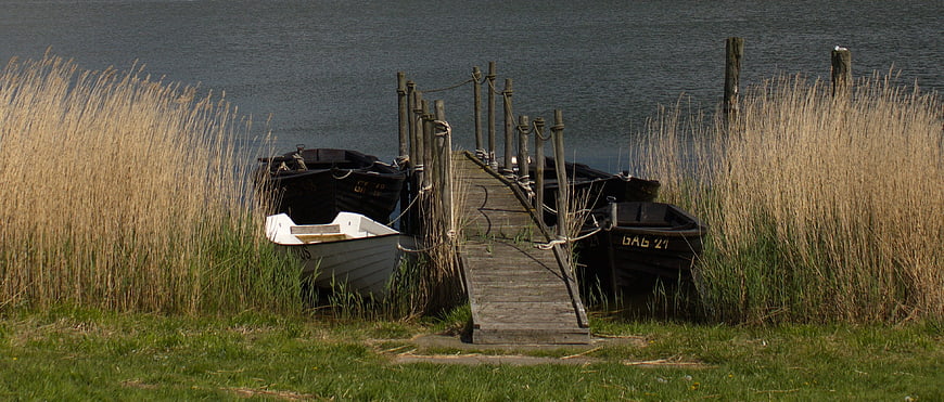 Small wooden boats docked at a rustic pier in Gager, Rügen Island, Germany