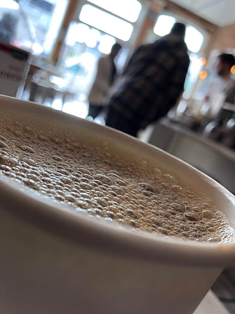 Close-up of frothy coffee in a cafe with blurred background