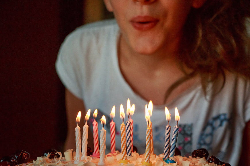 Girl Blowing Out Birthday Cake Candles Close Up