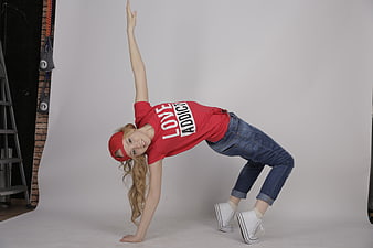 Young female breakdancer performing a dynamic freeze pose in a studio
