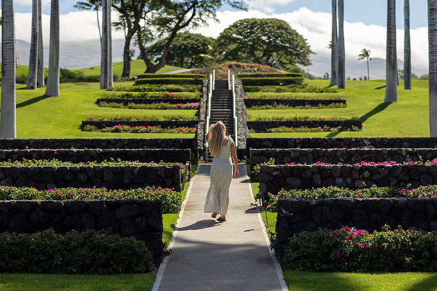Woman Walking Up Path in Tropical Garden with Palm Trees
