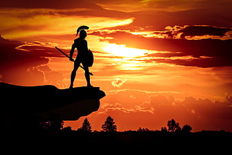 Silhouette of a Spartan Warrior Standing on a Cliff at Sunset
