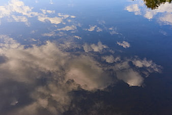 Serene Cloud Reflection on Calm Blue Water Surface
