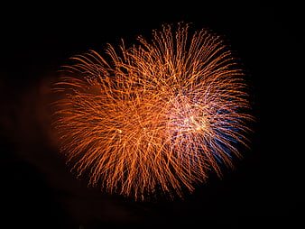 Orange and Blue Fireworks Burst in Night Sky
