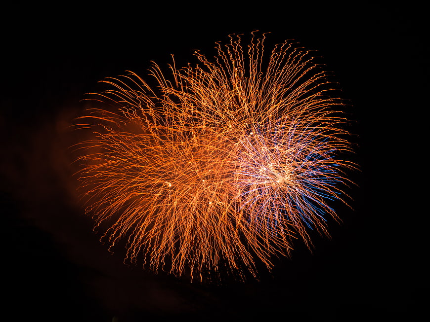 Orange and Blue Fireworks Burst in Night Sky