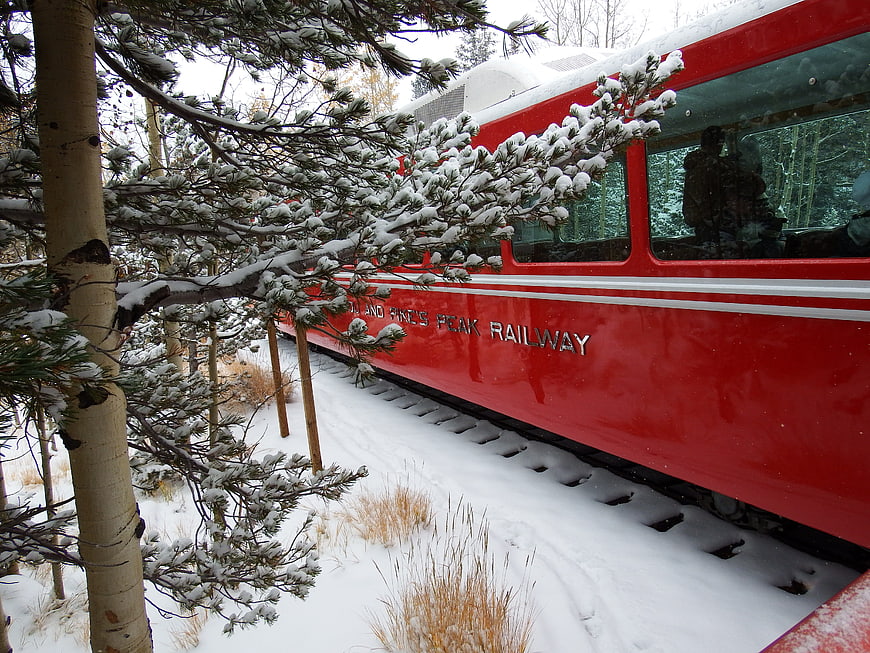 Red Pikes Peak Railway Train in Snowy Forest