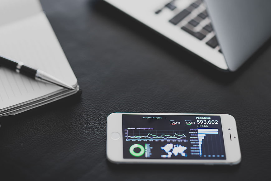 Smartphone displaying analytics dashboard on office desk