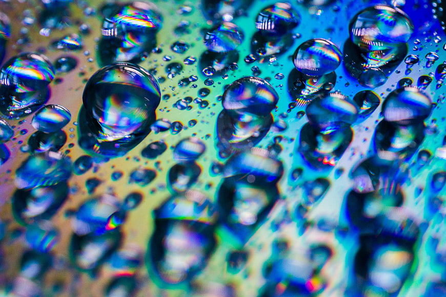 Abstract macro water droplets with iridescent rainbow reflections