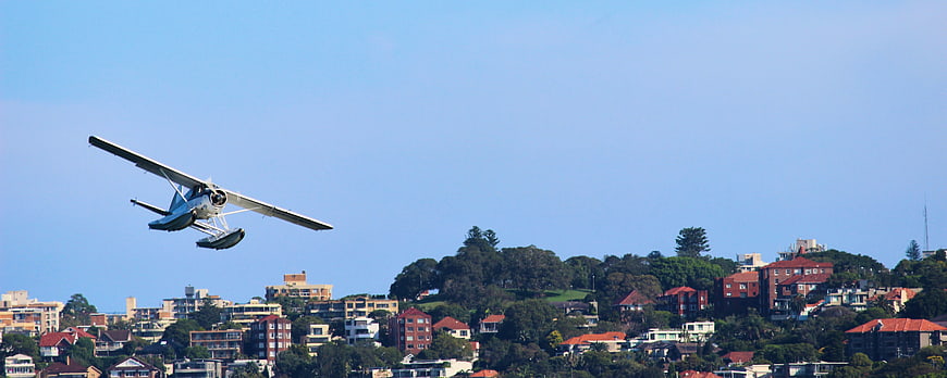 Seaplane Flying Over Coastal Cityscape