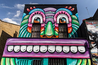 Vibrant Street Art Mural of a Face on Urban Building Facade