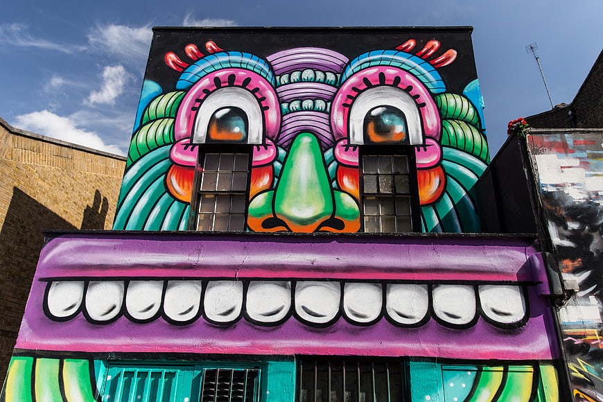 Vibrant Street Art Mural of a Face on Urban Building Facade