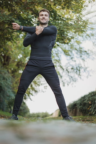 Athletic Man Stretching Outdoors in Park