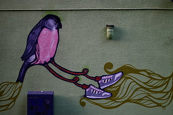 Colorful street art mural of bird with sneakers