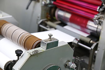 Close-up of offset printing machine rollers and paper feed