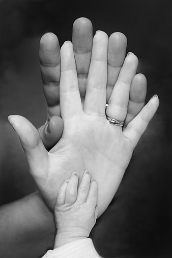 Black and white family hands with baby hand and wedding ring