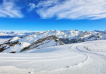 Snowy Ski Slope with Majestic Alpine Mountain Peaks