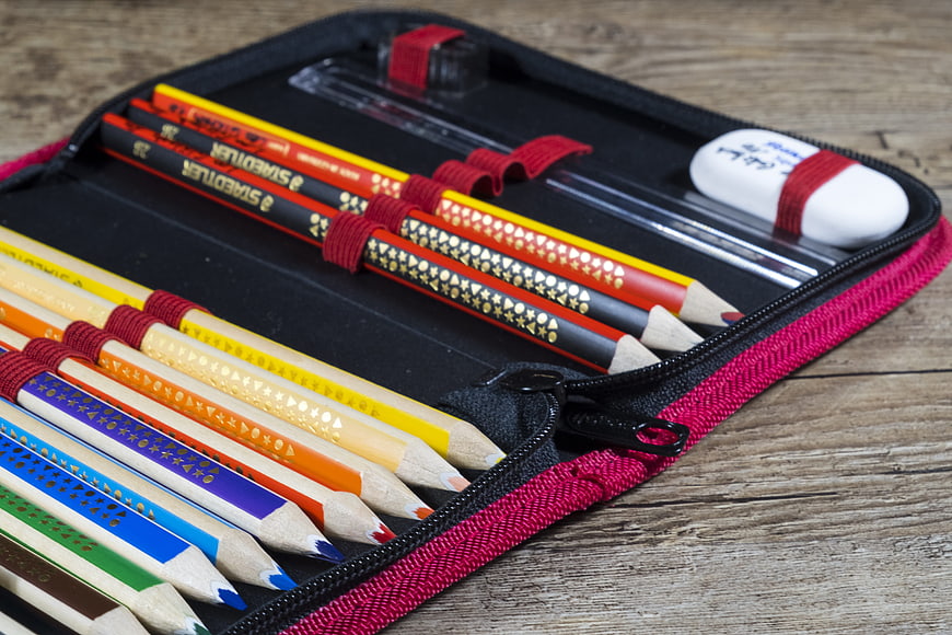 Open Pencil Case with Colored Pencils on Wooden Table