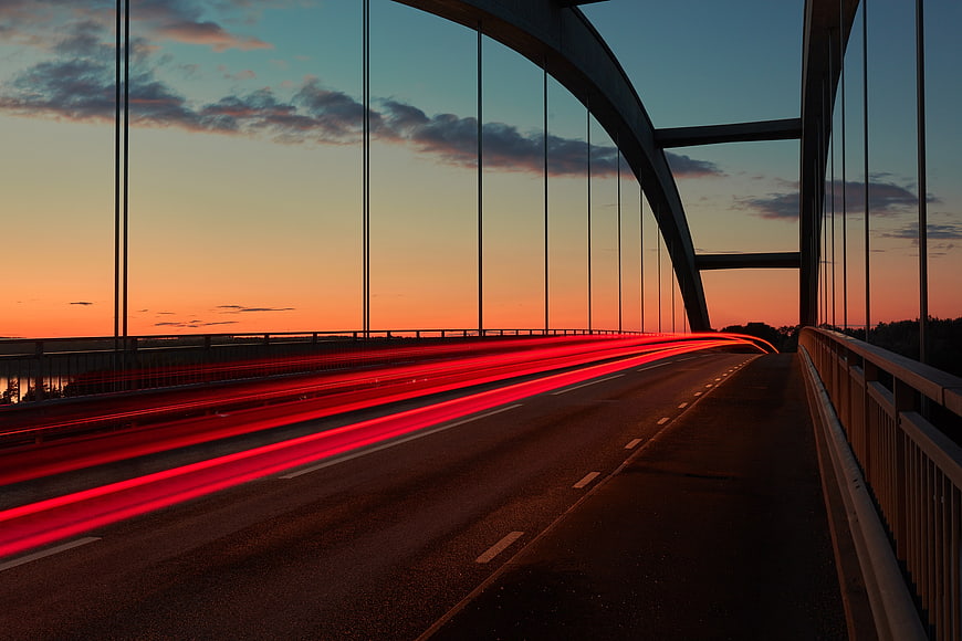 Red Light Trails on Bridge at Sunset