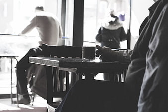 Black and white cafe scene with coffee cup on table