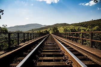Railway Tracks on Bridge Through Green Hills
