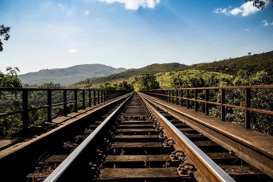 Railway Tracks on Bridge Through Green Hills