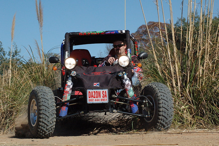Man driving custom off-road buggy on dirt track