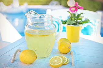 Refreshing Lemonade Pitcher With Lemons On Blue Poolside Table