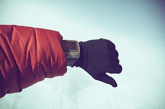 Hiker checking GPS watch in snowy winter landscape