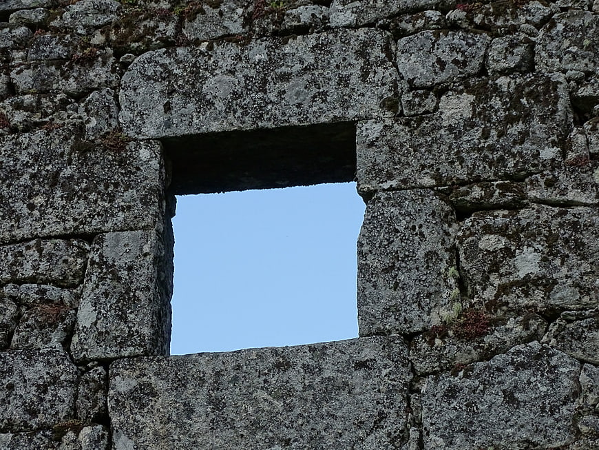 Square stone window opening in ancient mossy wall