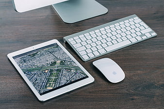 Modern workspace with tablet, keyboard, and mouse on wooden desk